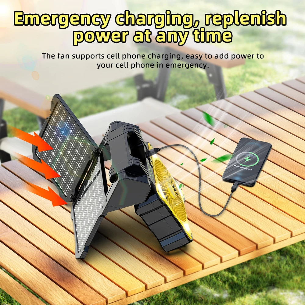 Solar-powered fan with phone charging feature on a wooden surface outdoors.